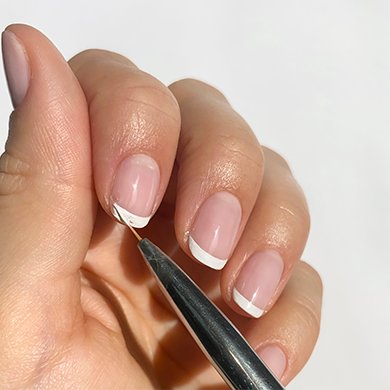 Fingernägel im French-Design werden mit einem speziellen Tool gestaltet.