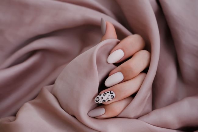Herbstliche Fingernägel in Nude-Look mit einem Fingernagel mit Leo-Muster 