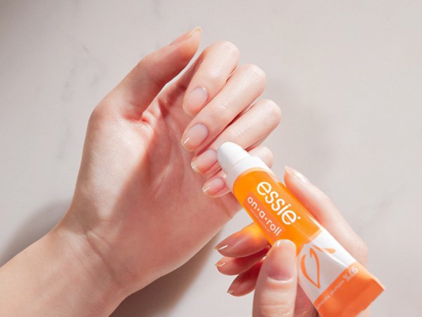 Produktbild einer Person, die sich das essie apricot oil aufträgt