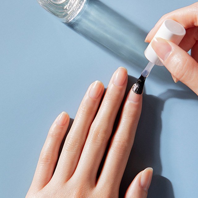 essie Nagelöl auf einem Handtuch mit essie Schriftzug und Nagelscheren.